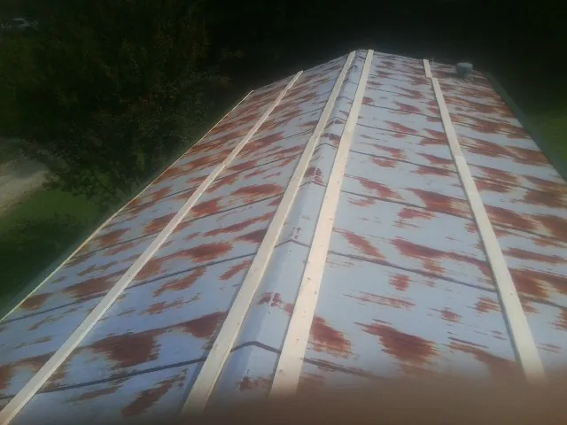 Rusted metal roof panels with new wood purlins before replacement — Storm Damage Roof Repair in Frankford by Roofing Brothers