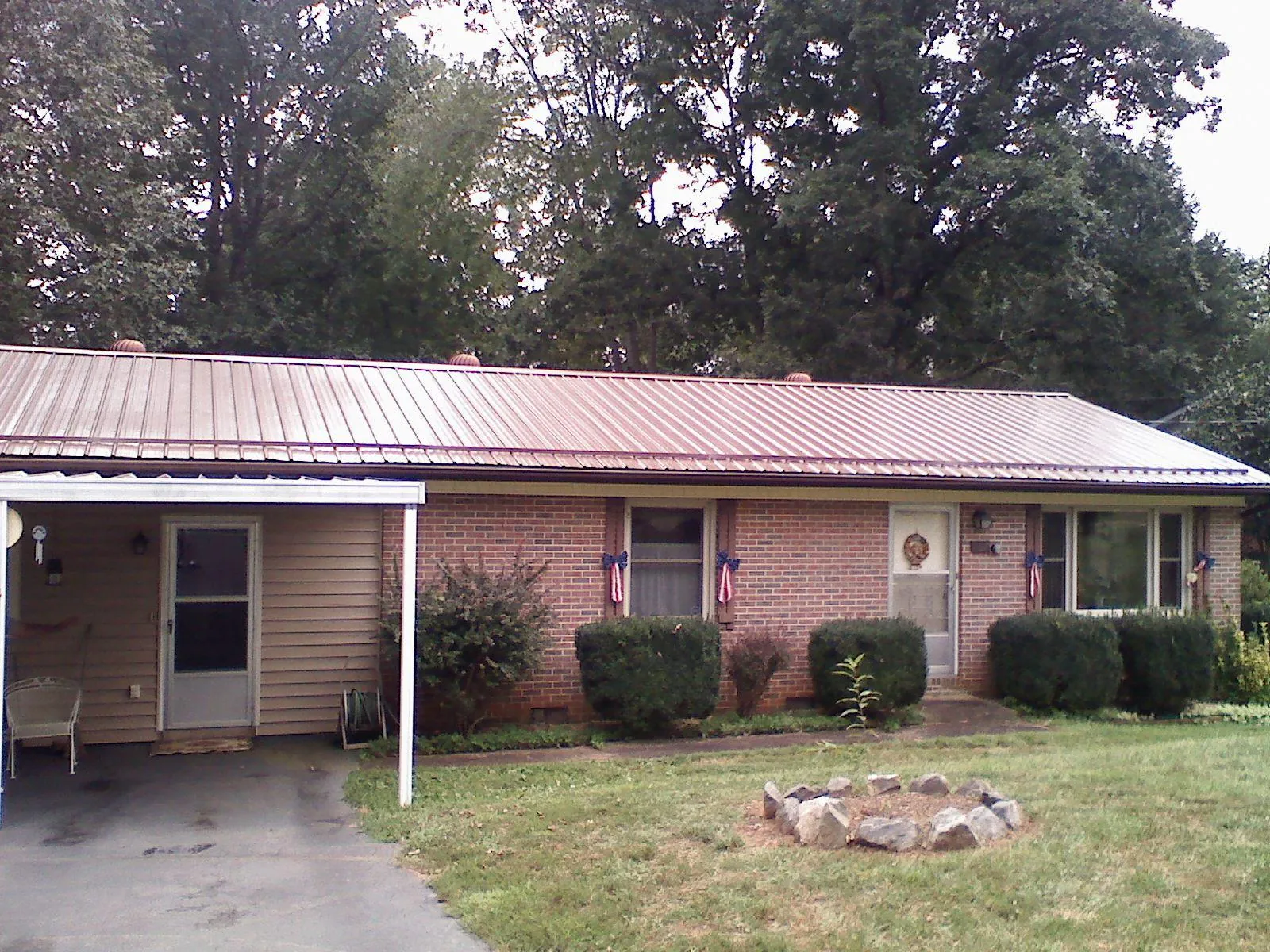 Bronze metal roof and carport on a brick ranch home — Roof Repair work by our crew in Frankford